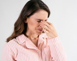woman holding nose with the sinus infection contagious pain